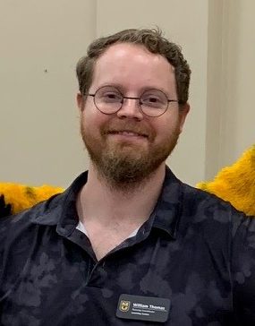 William wearing a black polo and name tag.